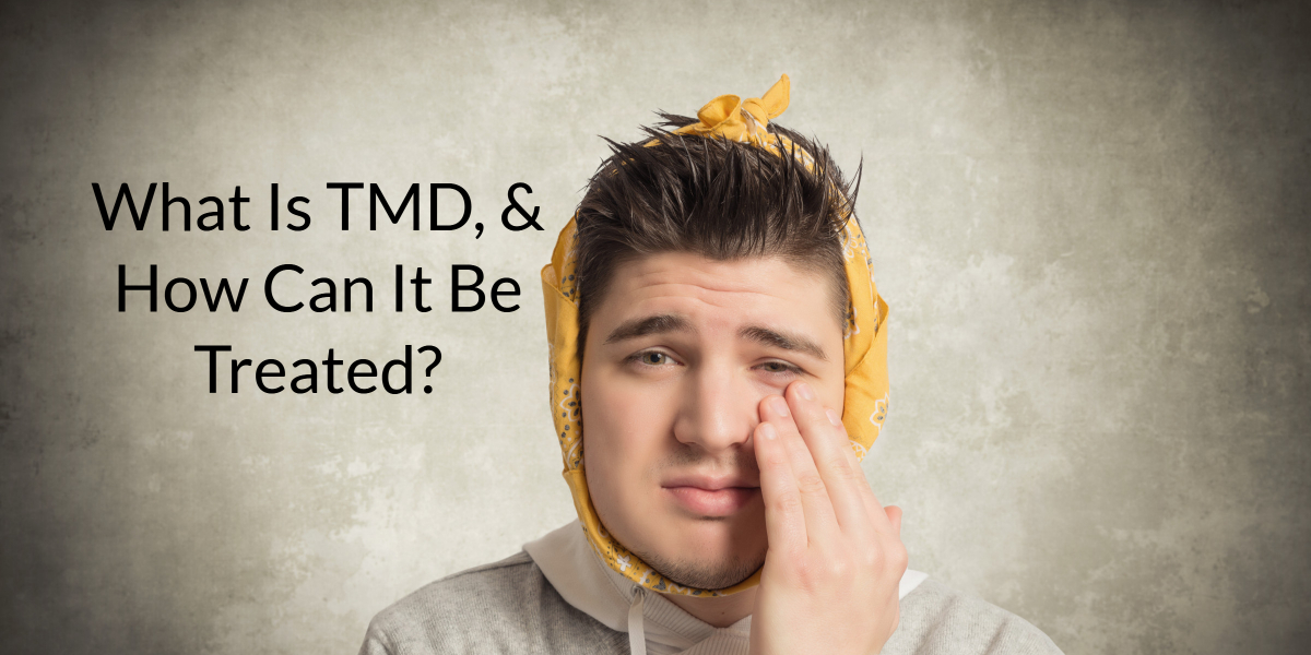Young man with his hand pressing on his cheek because of TMD pain