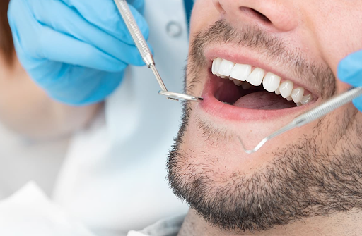 A dentist checking a man's teeth