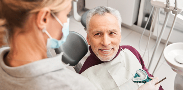 Dentist holding Dentures